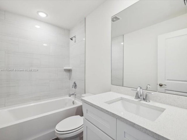 full bathroom featuring tiled shower / bath combo, toilet, and vanity