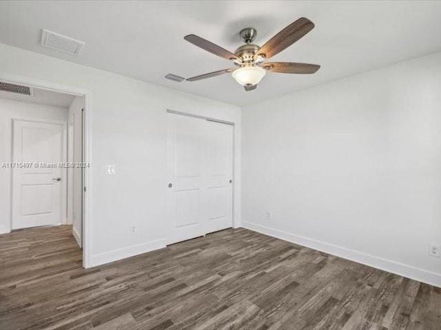 unfurnished bedroom featuring a closet, ceiling fan, and dark hardwood / wood-style flooring