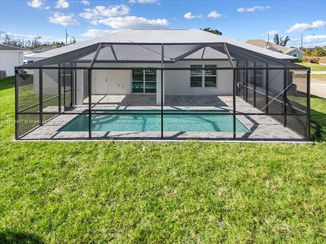 rear view of house with a patio area, a lanai, and a lawn