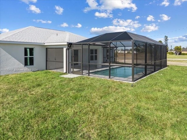 rear view of house with glass enclosure, a yard, and a patio