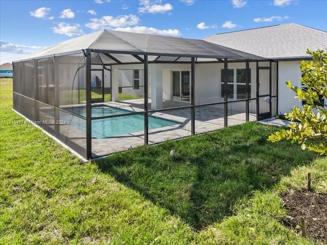 view of swimming pool featuring a lawn, a patio area, and a lanai