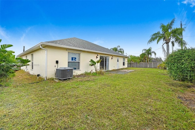 back of property with central air condition unit and a lawn