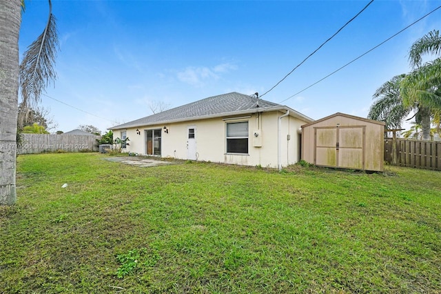 rear view of property with a yard and a storage shed