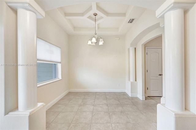 tiled empty room featuring decorative columns, an inviting chandelier, and coffered ceiling