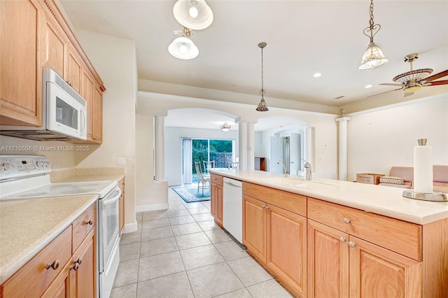 kitchen with white appliances, decorative light fixtures, ornate columns, sink, and light tile patterned flooring