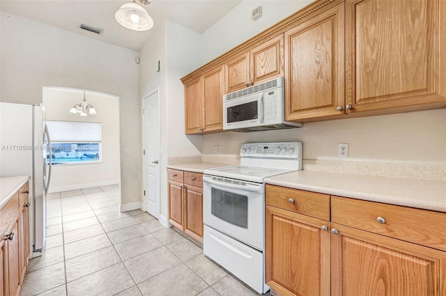 kitchen featuring light tile patterned flooring, white appliances, pendant lighting, and an inviting chandelier