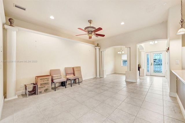 interior space with light tile patterned flooring, ceiling fan, and ornate columns