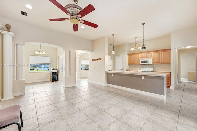 kitchen with kitchen peninsula, light tile patterned flooring, white appliances, and light brown cabinetry