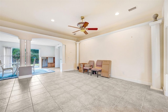 unfurnished room with crown molding, light tile patterned floors, ceiling fan, and ornate columns