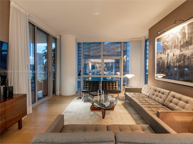 living room with a wall of windows and light hardwood / wood-style flooring