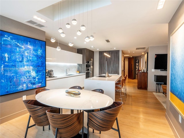 dining space with sink and light hardwood / wood-style floors