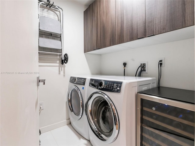 laundry area with washer and clothes dryer, cabinets, light tile patterned floors, and beverage cooler