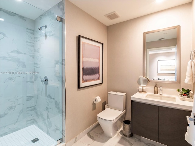 bathroom with toilet, vanity, and tiled shower