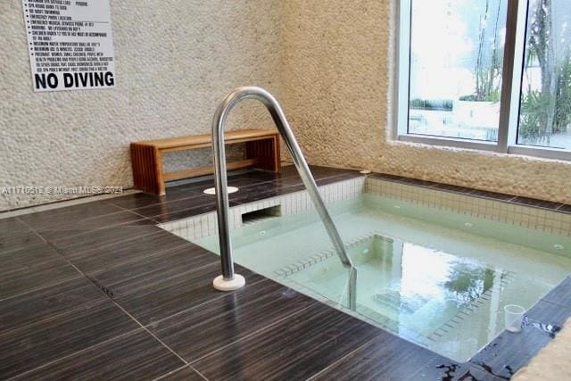 view of pool with an indoor hot tub