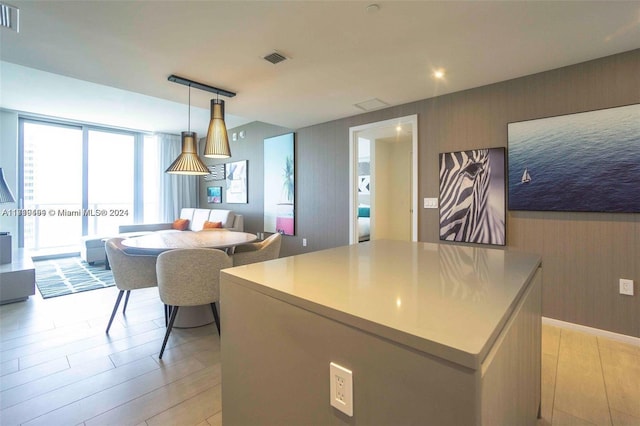 kitchen with a kitchen island, light hardwood / wood-style floors, and decorative light fixtures