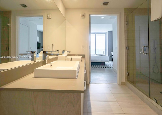 bathroom featuring tile patterned floors, vanity, and a shower with shower door