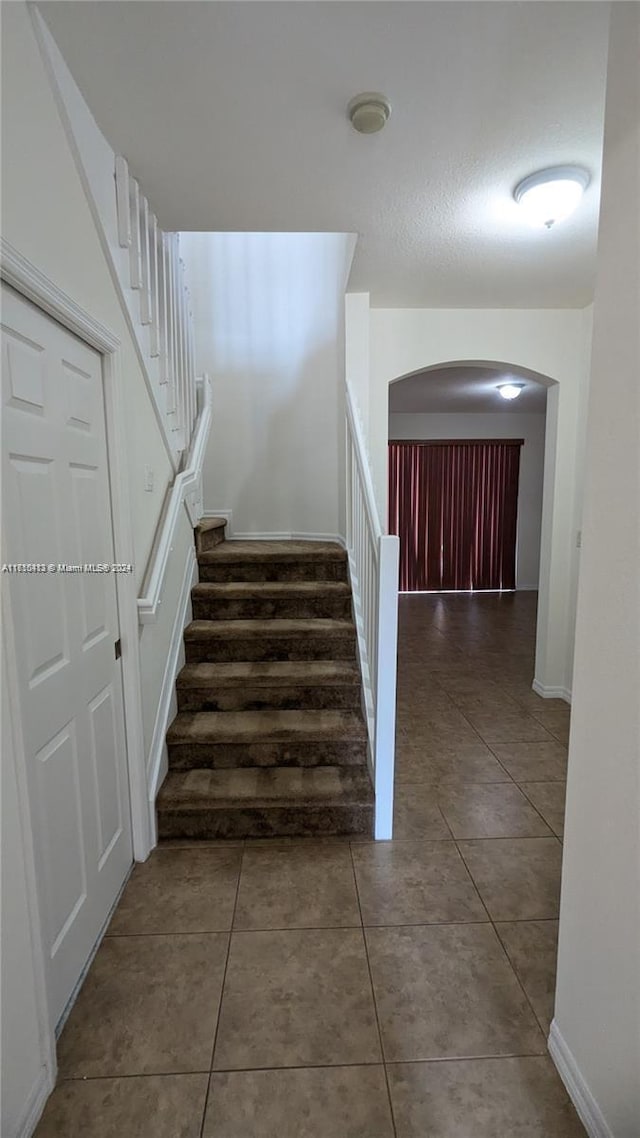 stairway with tile patterned floors