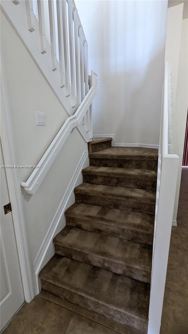 staircase featuring tile patterned floors