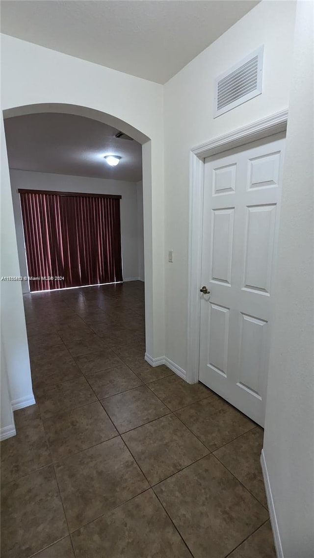 hallway with dark tile patterned floors