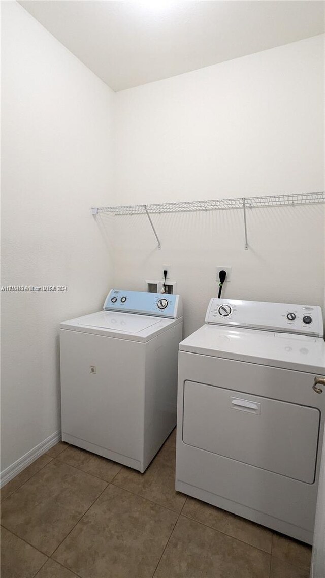 washroom with tile patterned flooring and washing machine and clothes dryer