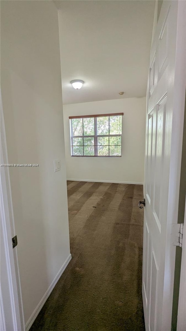 spare room with dark colored carpet