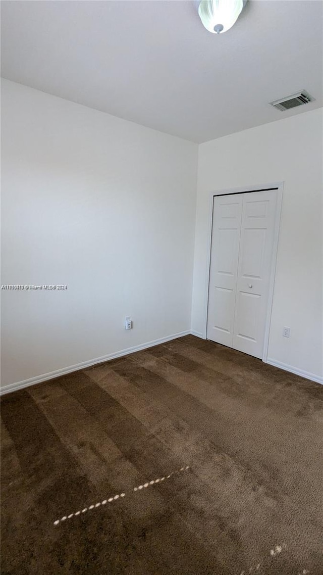 unfurnished bedroom featuring carpet floors and a closet