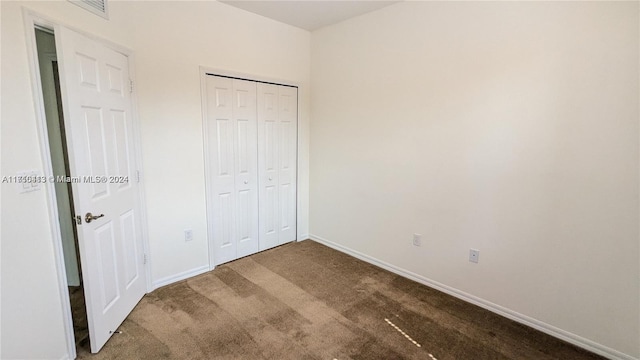 unfurnished bedroom featuring carpet flooring and a closet