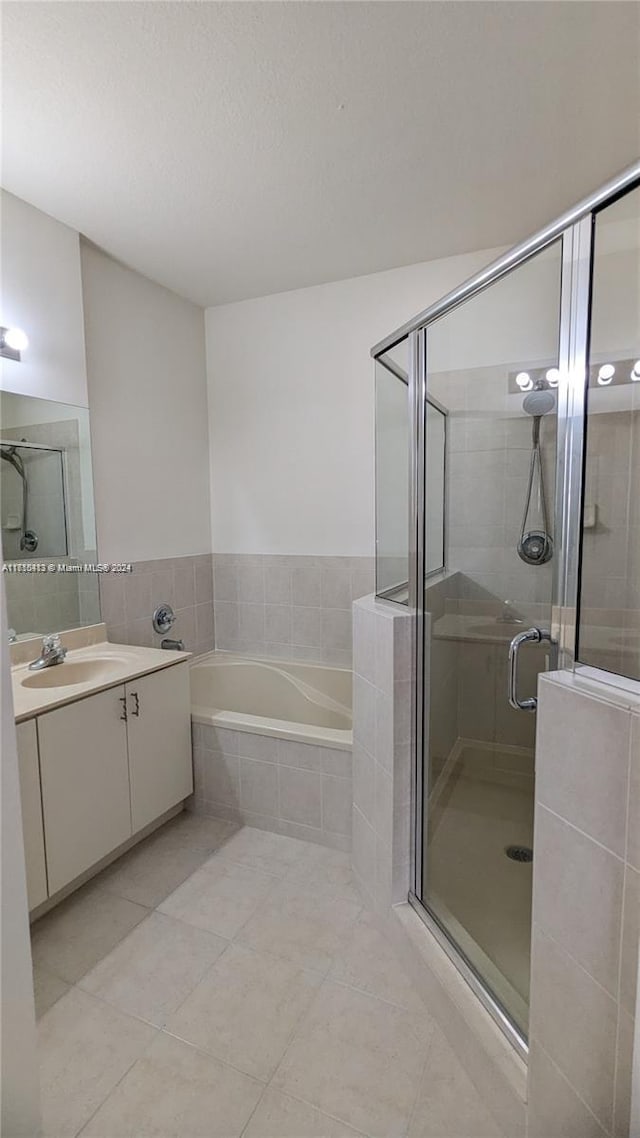 bathroom featuring vanity, tile patterned flooring, and plus walk in shower