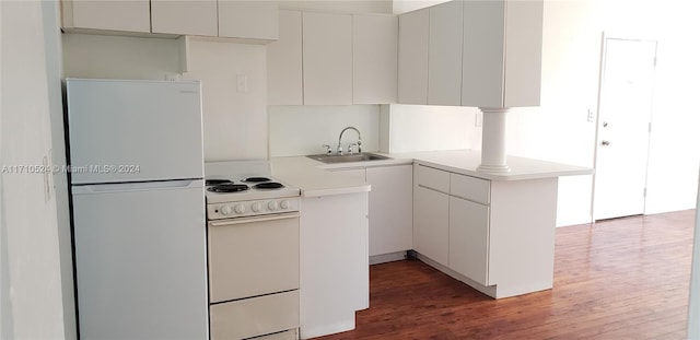 kitchen featuring kitchen peninsula, dark hardwood / wood-style flooring, white appliances, sink, and white cabinets