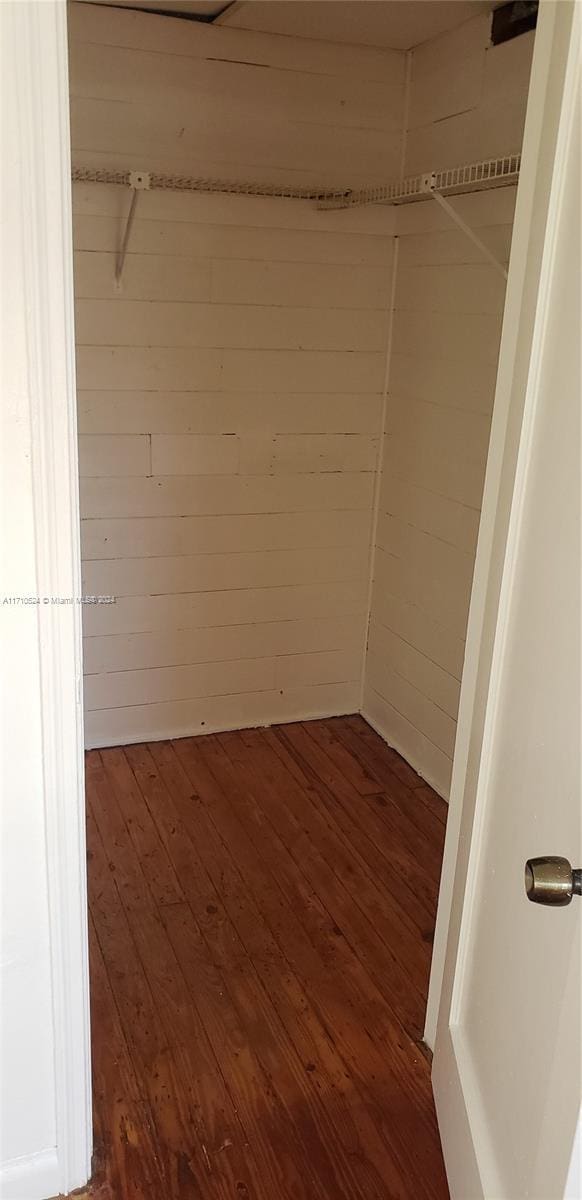 walk in closet with dark hardwood / wood-style flooring