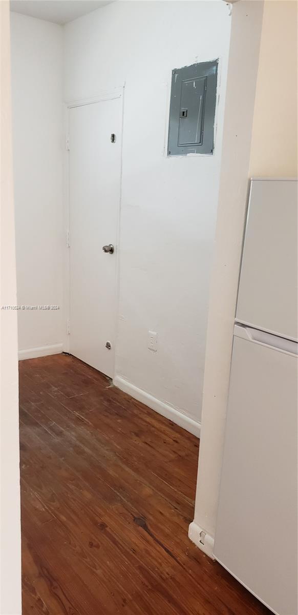 spare room with dark hardwood / wood-style flooring and electric panel