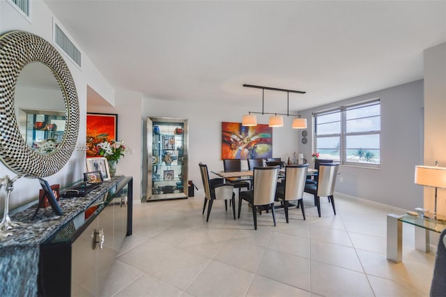 dining room with light tile patterned floors, visible vents, and baseboards