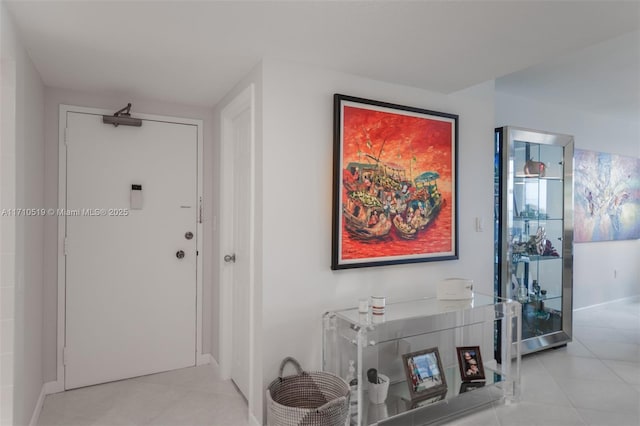 corridor featuring light tile patterned flooring and baseboards