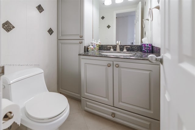 bathroom with toilet, tile patterned flooring, and vanity