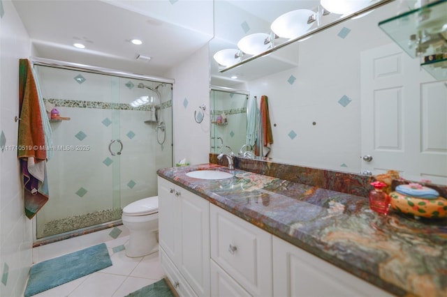 full bathroom with a stall shower, vanity, toilet, and tile patterned floors