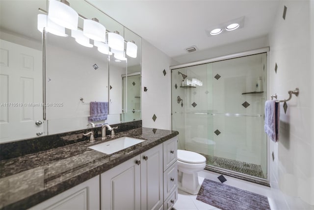 bathroom featuring toilet, a stall shower, visible vents, and vanity