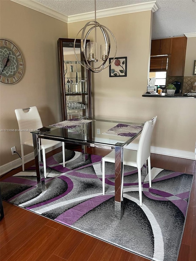 dining space featuring a textured ceiling, hardwood / wood-style flooring, an inviting chandelier, and crown molding