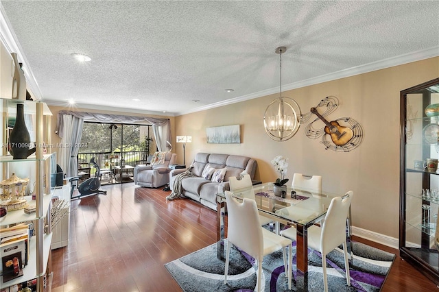 dining space featuring a chandelier, dark wood-type flooring, a textured ceiling, and ornamental molding