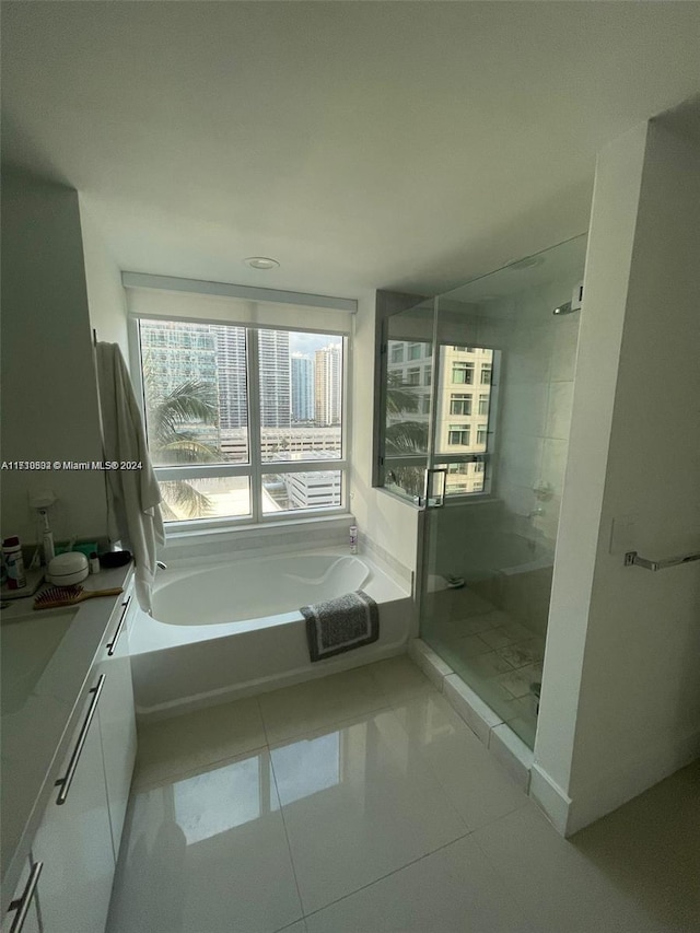 bathroom featuring tile patterned flooring, vanity, and separate shower and tub