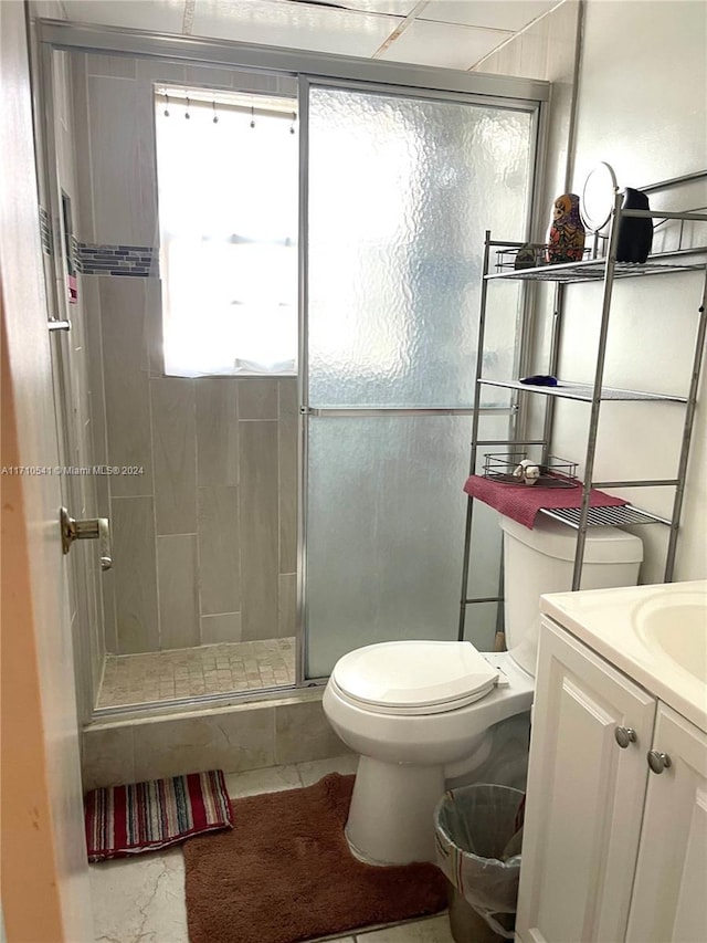 bathroom featuring tile patterned floors, toilet, vanity, and walk in shower