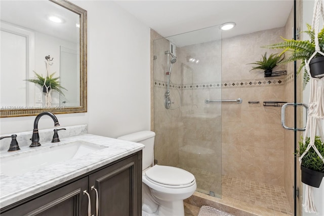 bathroom with tile patterned floors, vanity, toilet, and walk in shower