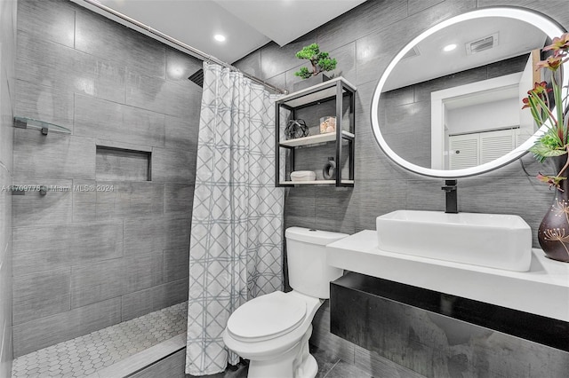 bathroom featuring a shower with shower curtain, vanity, toilet, and tile walls