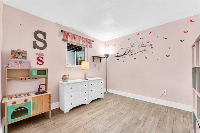 bedroom with crown molding, sink, and a textured ceiling