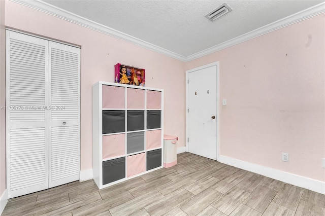 unfurnished bedroom with crown molding, a closet, and a textured ceiling