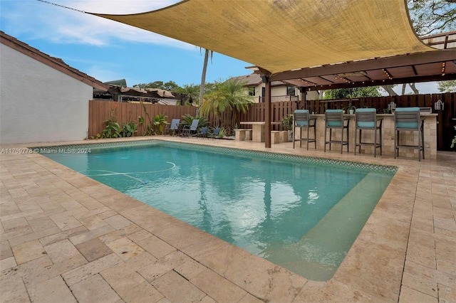 view of pool with a patio area and a bar