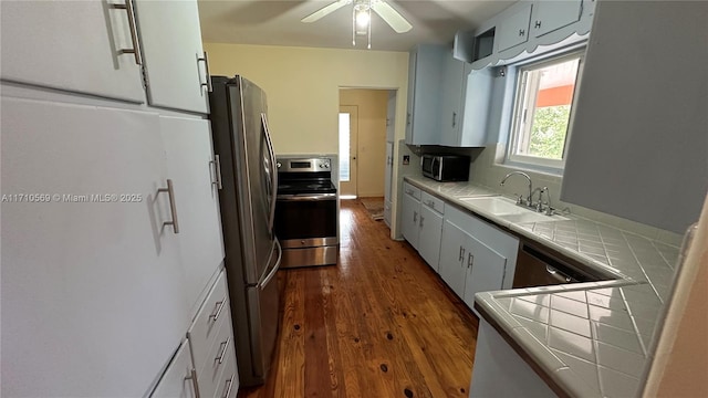 kitchen featuring sink, dark wood-type flooring, tile countertops, and appliances with stainless steel finishes