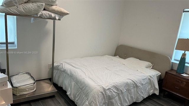 bedroom with dark wood-type flooring