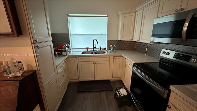 kitchen featuring appliances with stainless steel finishes, dark hardwood / wood-style floors, sink, and backsplash