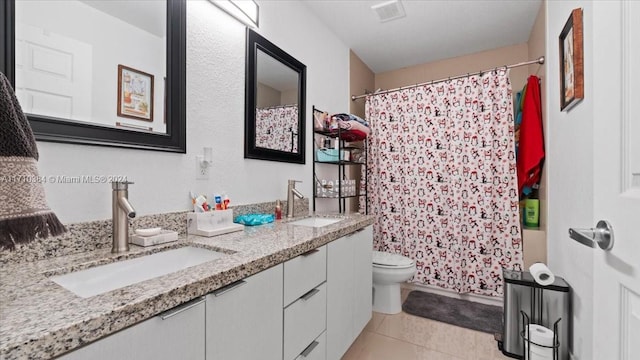 bathroom with toilet, vanity, tile patterned floors, and walk in shower