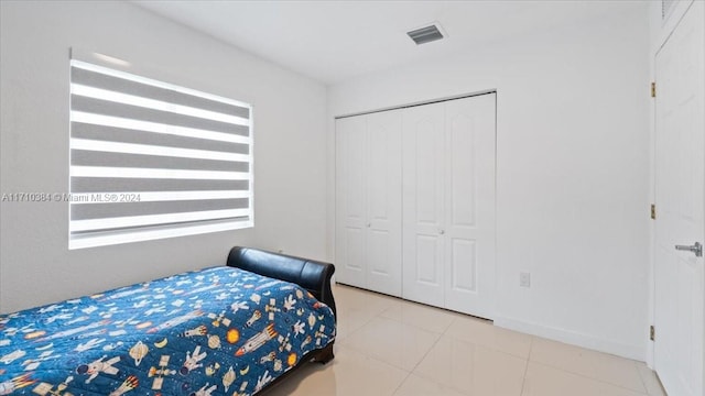 bedroom with a closet and light tile patterned flooring